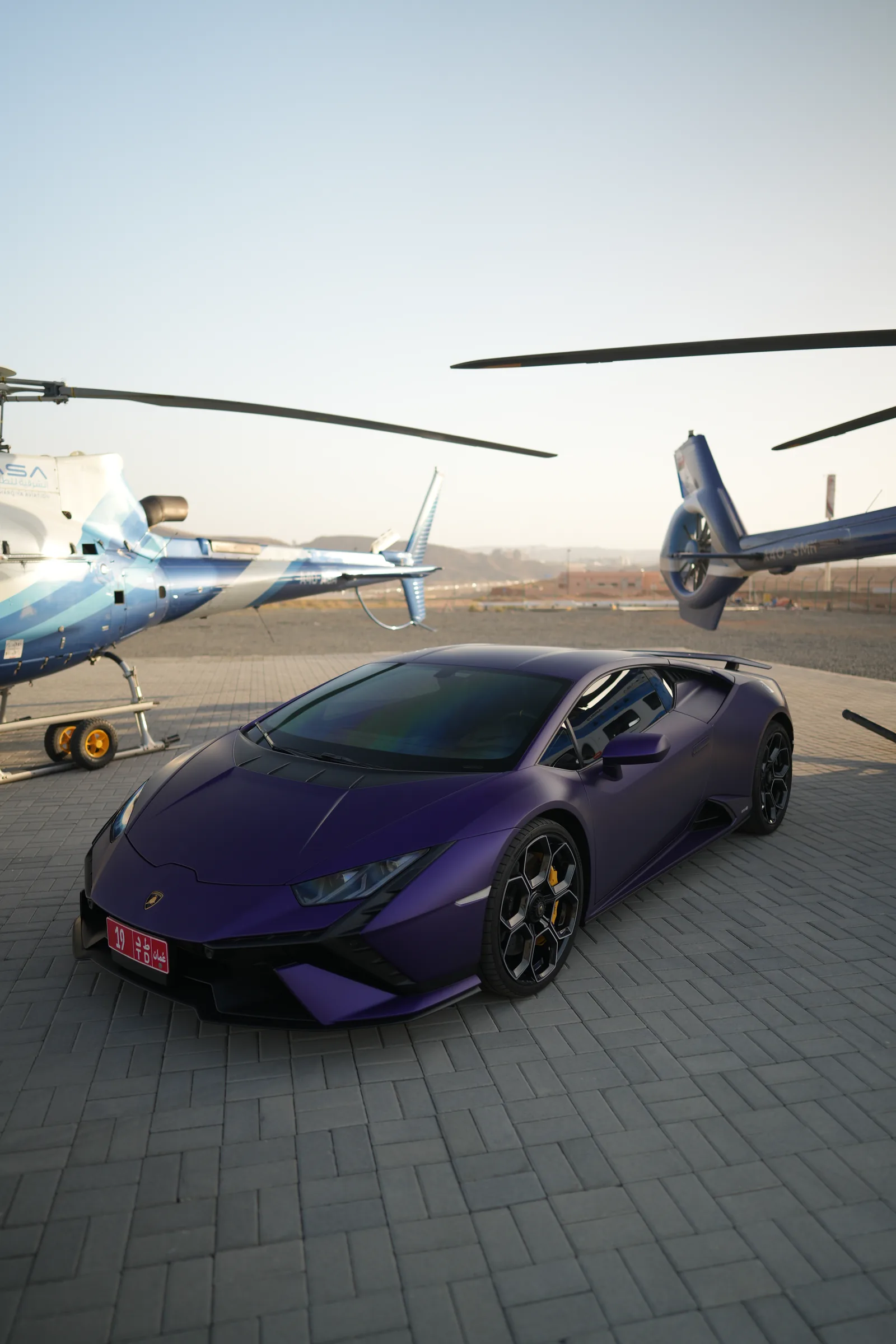 Aerial side view of Lamborghini Huracán beside a helicopter