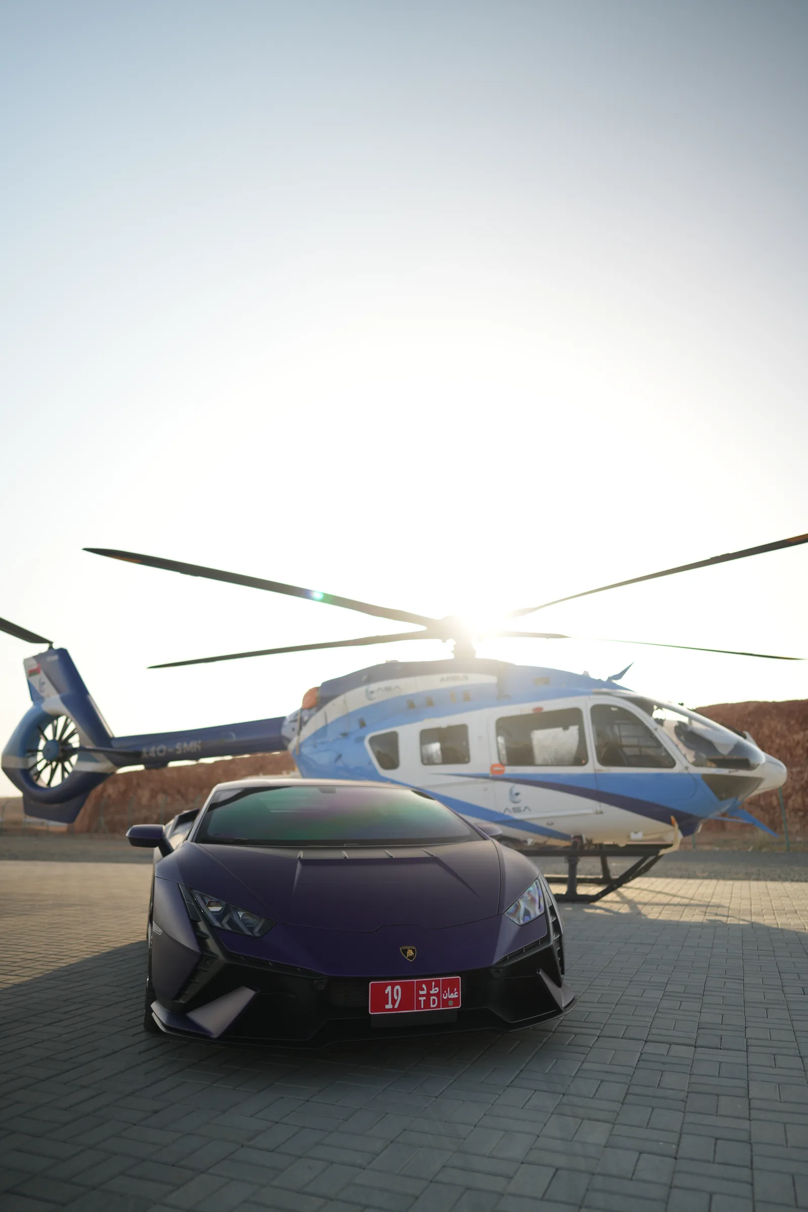 Close-up front detail of Lamborghini Huracán with helicopter in background