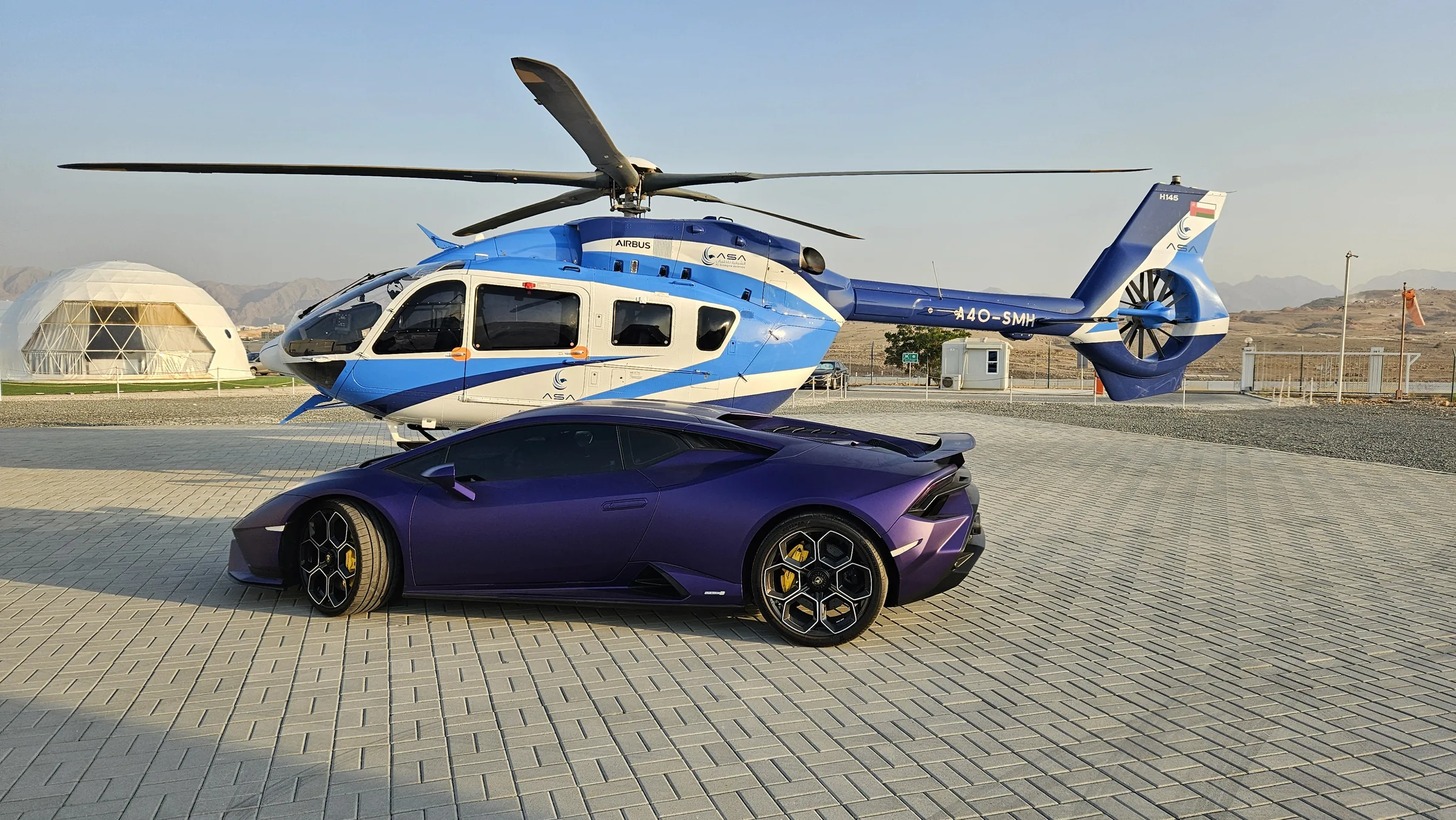 Purple Lamborghini Huracán with helicopter and geodesic dome backdrop
