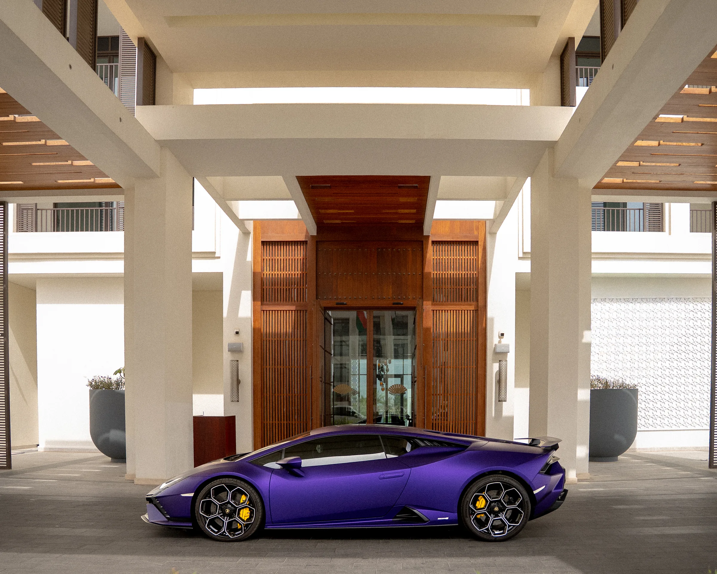Purple Lamborghini Huracán parked at a luxury hotel entrance in Muscat