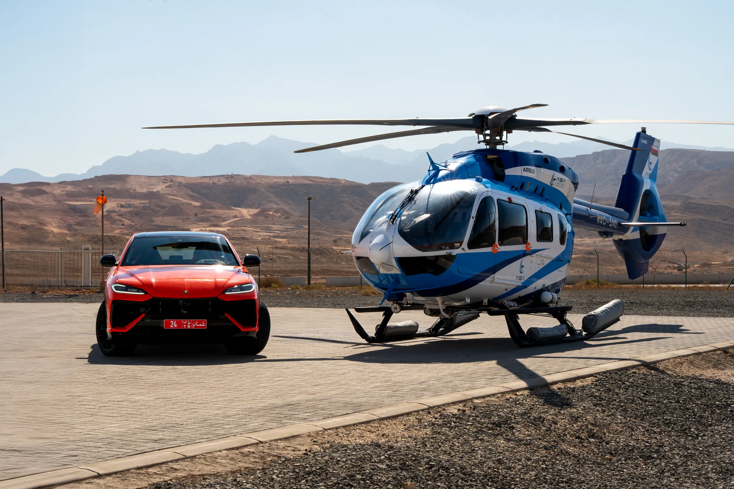 Lamborghini Urus front view on a helipad with mountain backdrop