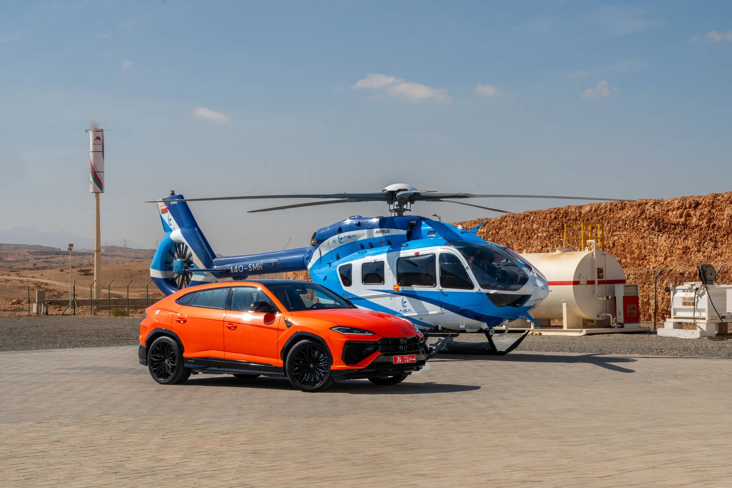 Lamborghini Urus and helicopter in Oman's desert mountains